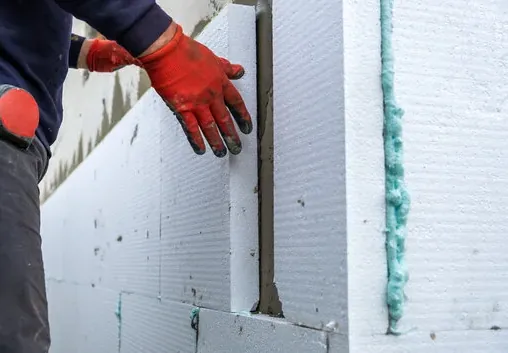 Rigid foam insulation boards installed on a shared wall to cut heat and noise