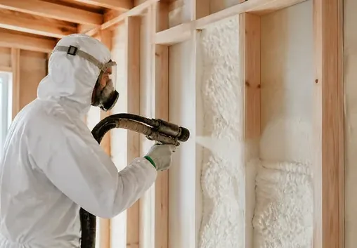 Spray foam insulation being installed in open wall framing during a rebuild